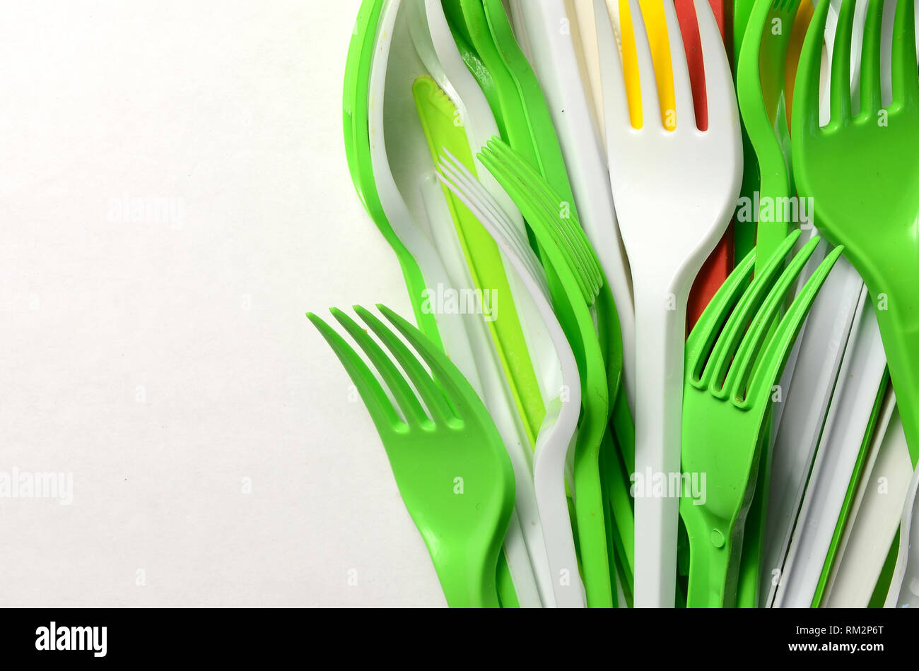 Pile of bright yellow, green and white plastic kitchenware single use