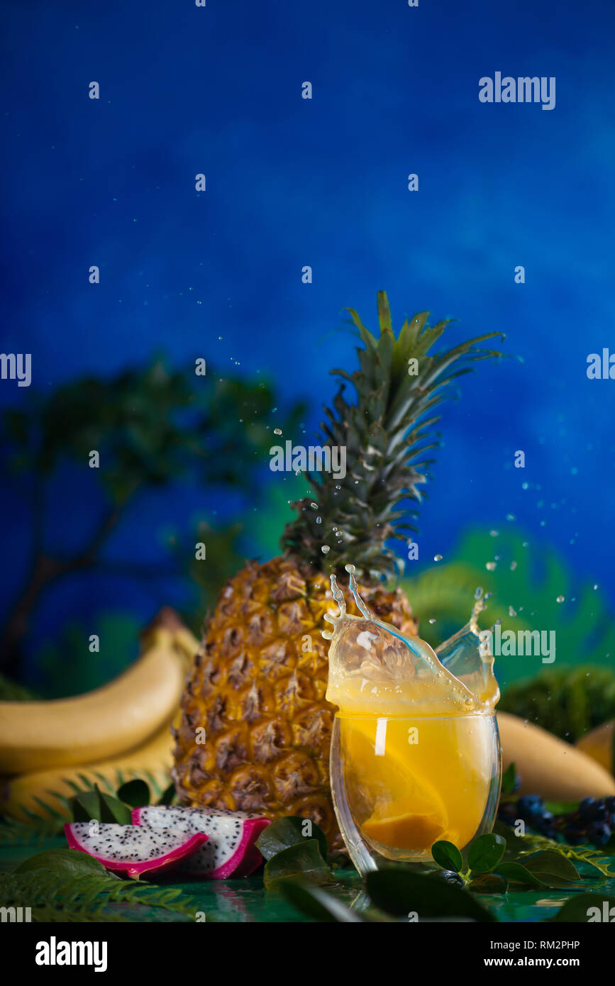 Fresh juice dynamic splash. Tropical fruits, bananas, pineapple, and dragon fruit. Exotic drink action photography with copy space Stock Photo