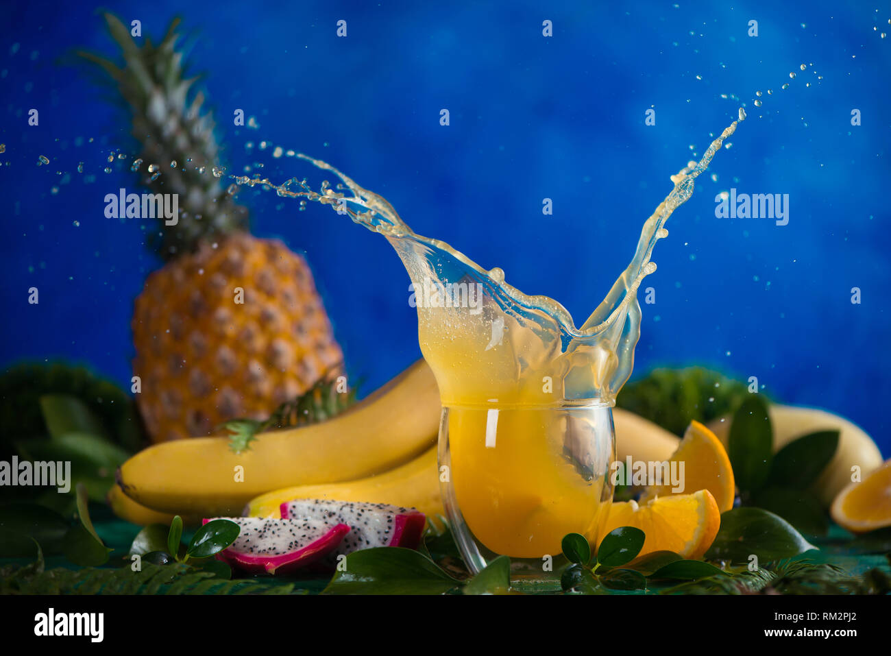 Fresh juice dynamic splash. Tropical fruits, bananas, pineapple, and dragon fruit. Exotic drink action photography with copy space Stock Photo