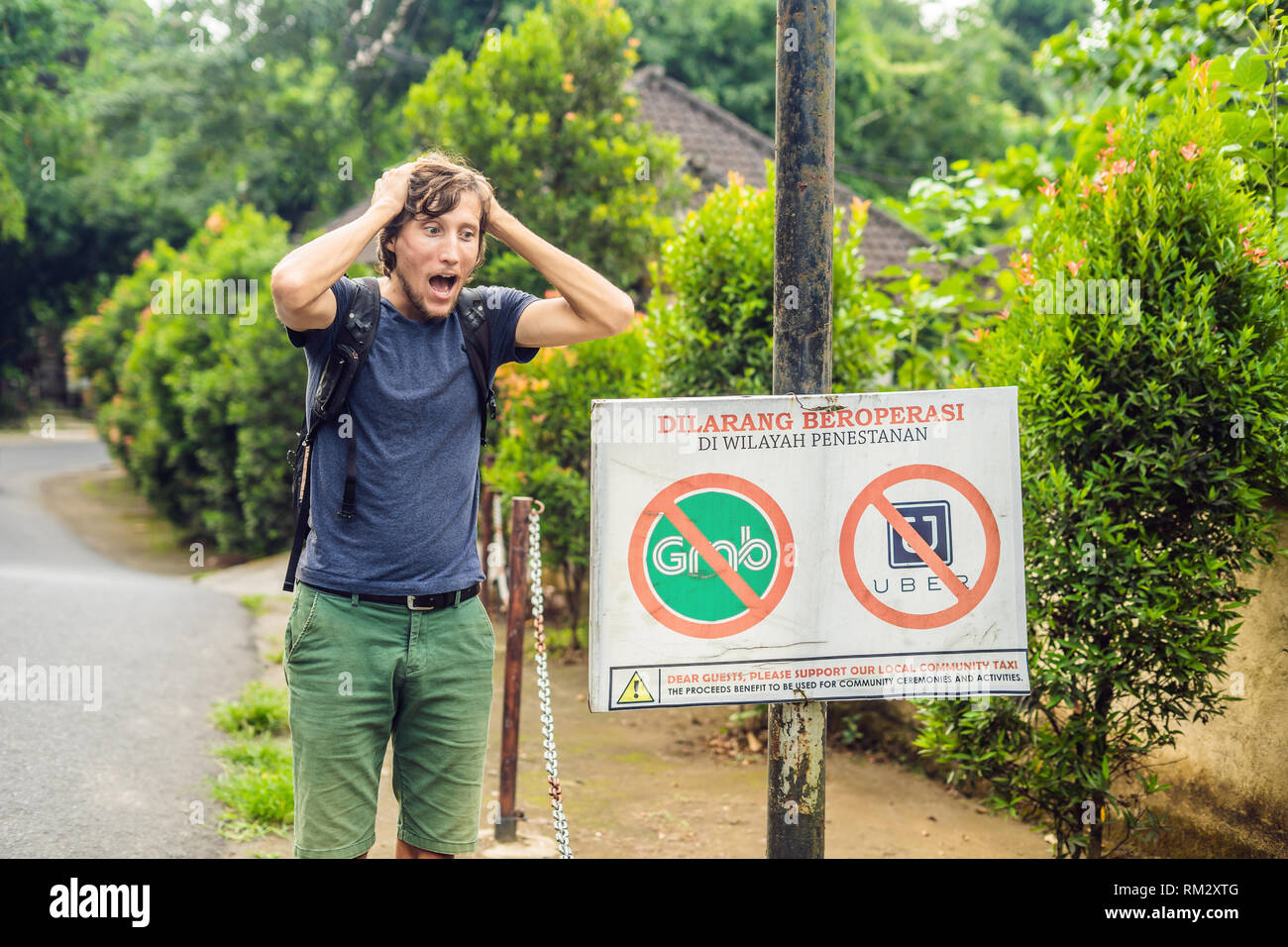 BALI, INDONESIA - 21 May, 2018: Young man looks at protest sign on 