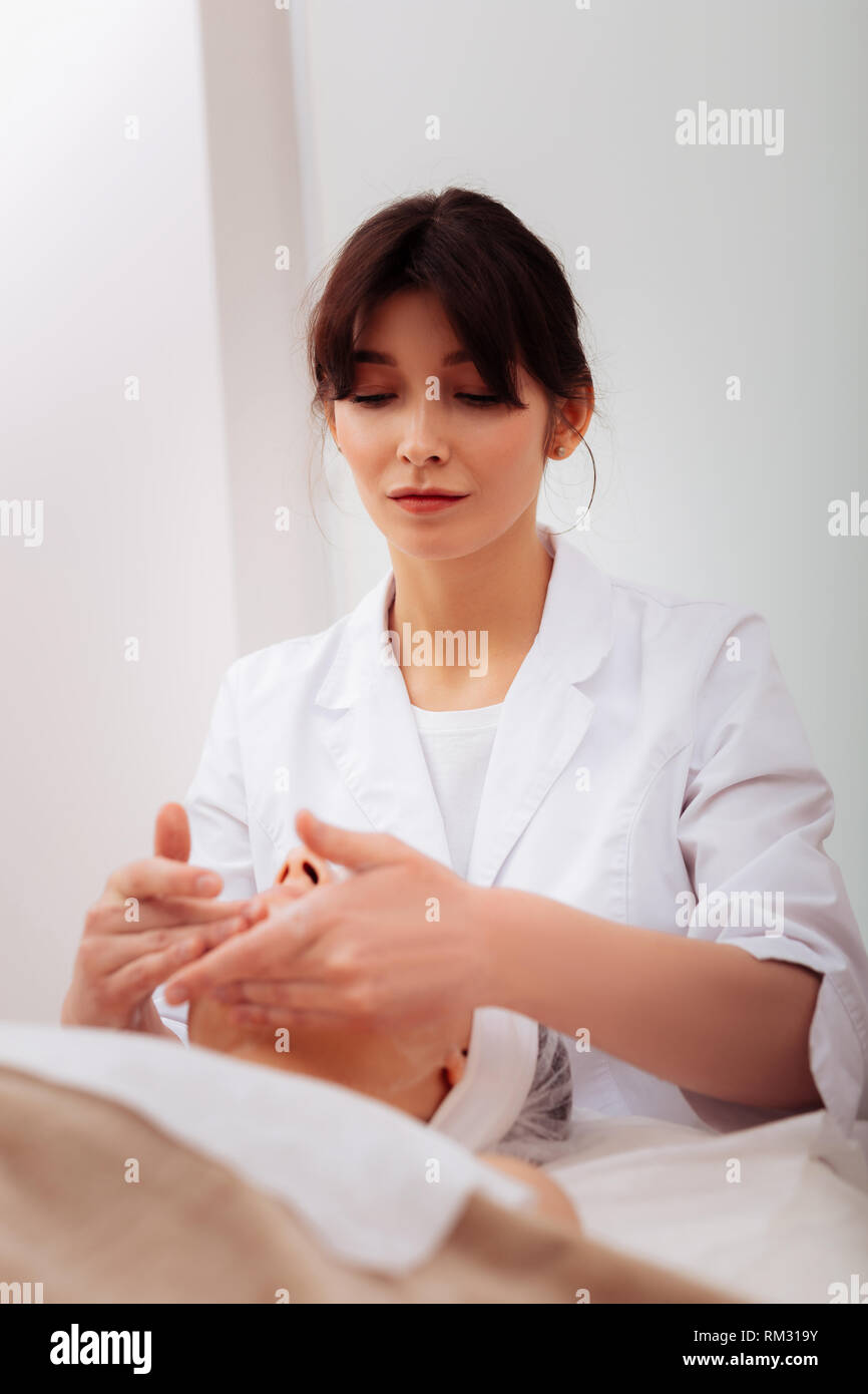 Pleasant nice woman working in the beauty clinic Stock Photo
