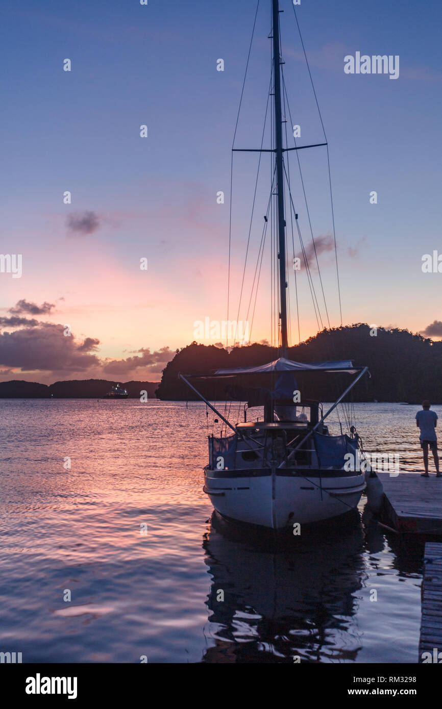 Sailboat moored for the day at dock as sun sets in pink sky Stock Photo ...