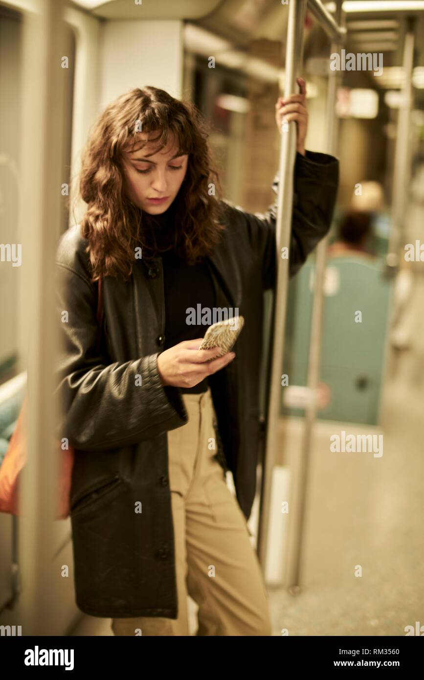 Woman in public transport, using smartphone, Berlin, Germany. Stock Photo