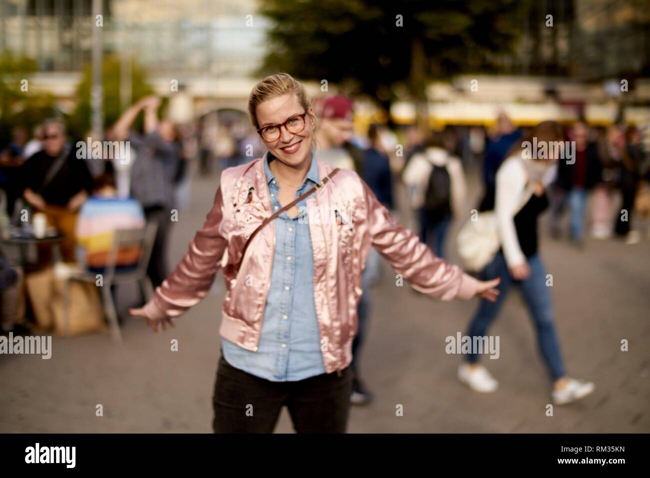 Lively woman with open arms dancing at Alexanderplatz, Berlin, Germany Stock Photo