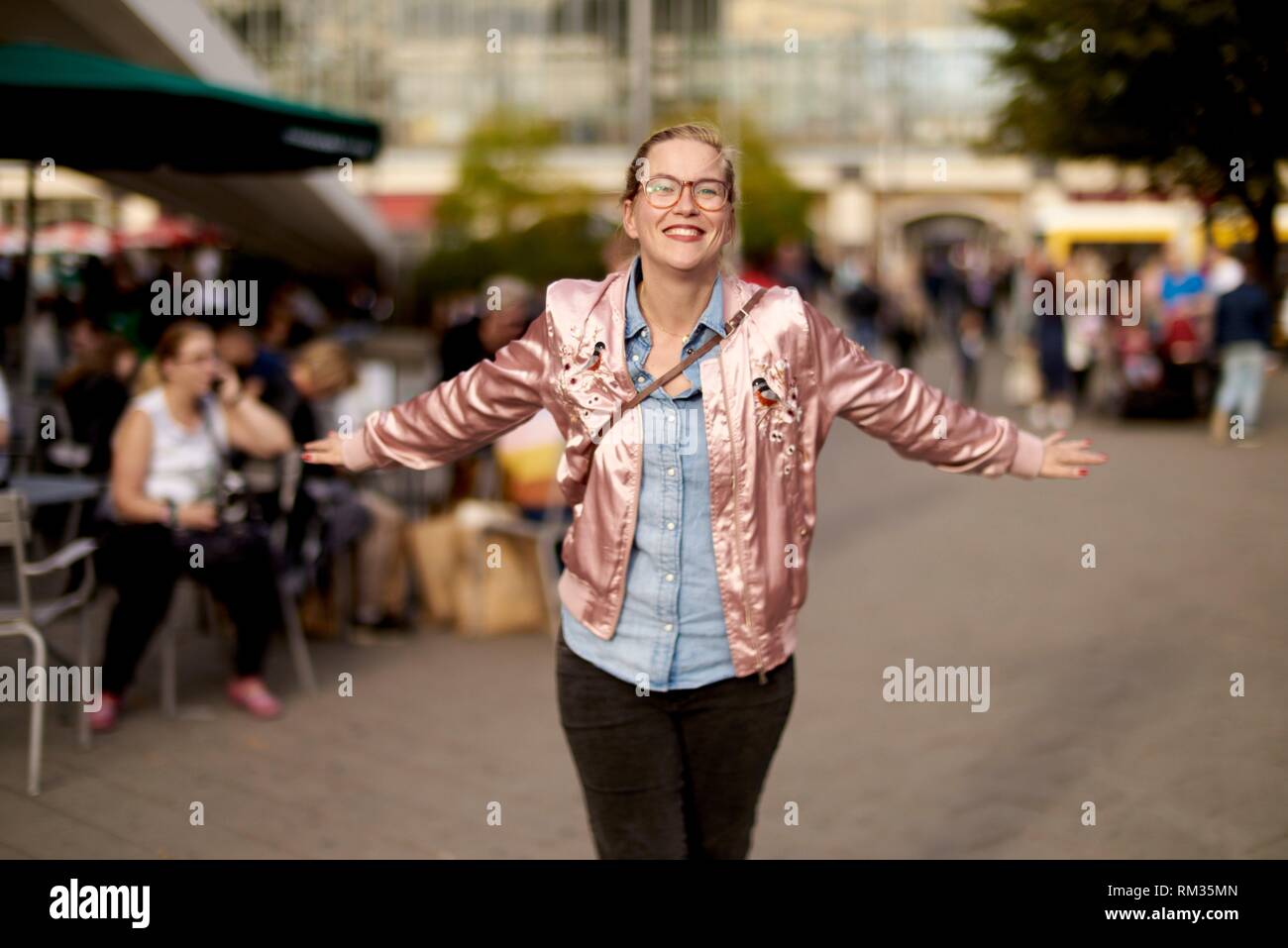 Lively woman with open arms dancing at Alexanderplatz, Berlin, Germany Stock Photo