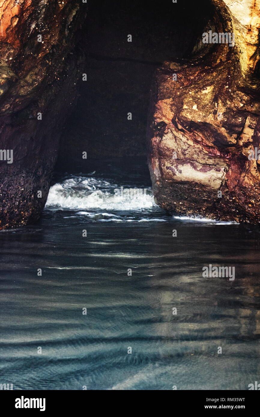 Natural formed cave where the ocean comes through the rock at Wharariki
