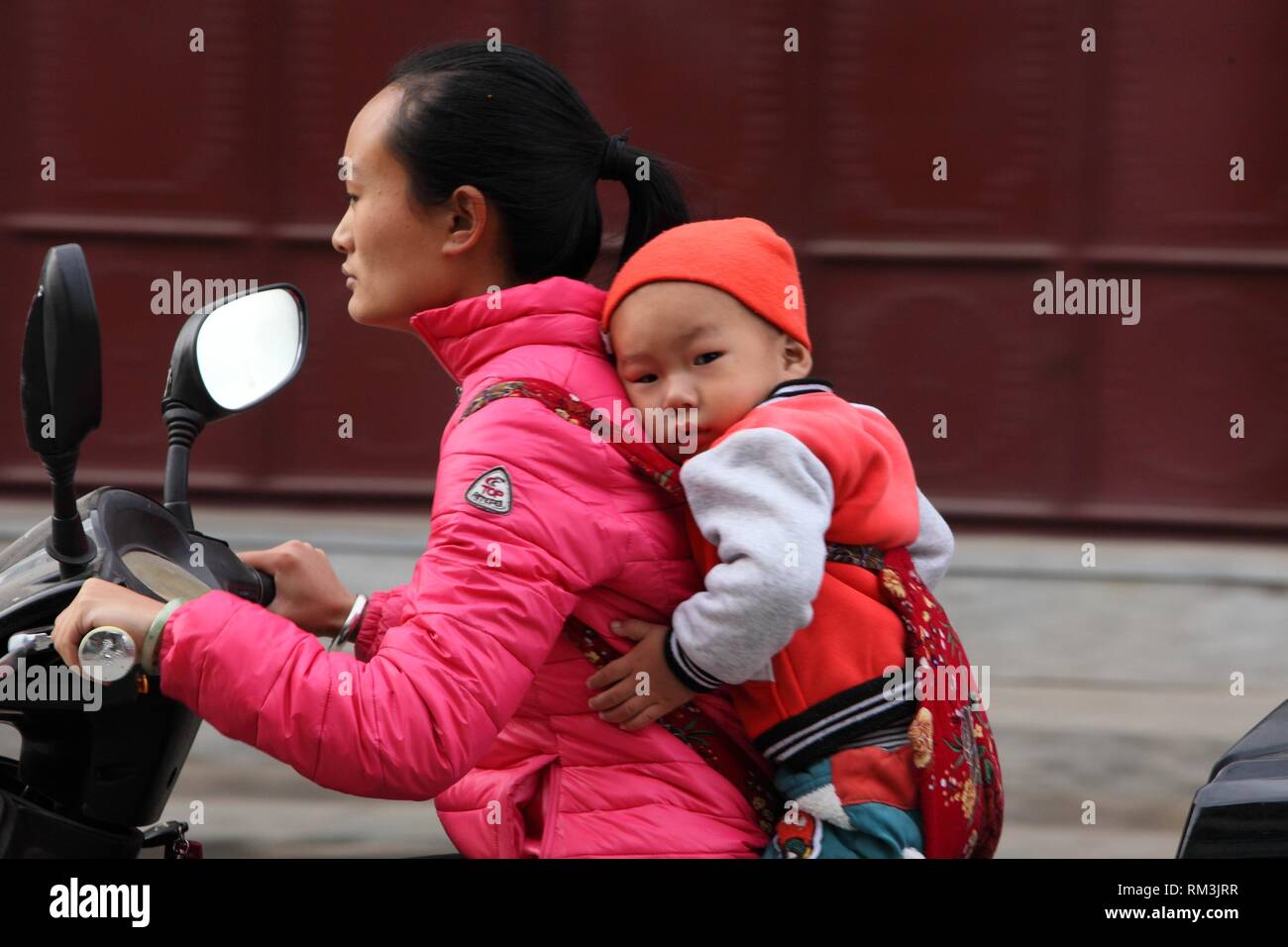 Mother and son with motorcycle, Yunnan province, China Stock Photo