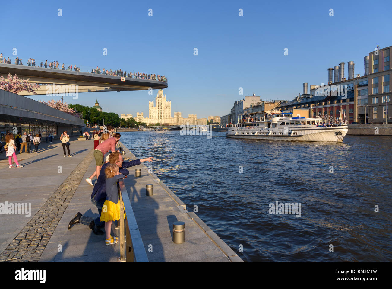 Moscow, Russia -13 May 2018: People walk along the embankment of Moscow river near the park Zaryadye and the Floating Bridge Stock Photo