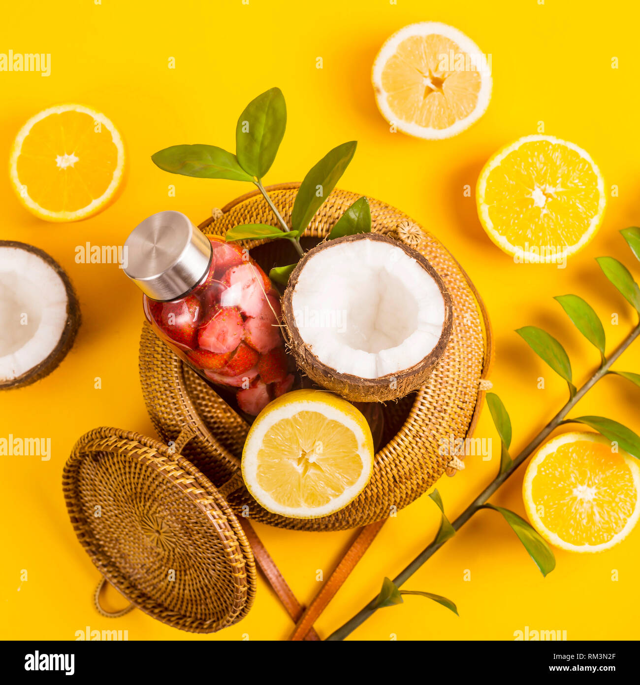 https://c8.alamy.com/comp/RM3N2F/water-with-strawberries-oranges-lemons-and-coconuts-on-yellow-with-a-straw-bag-RM3N2F.jpg