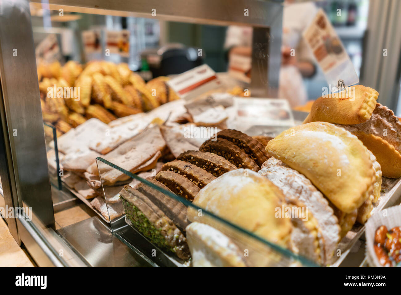 Buns, pies, biscuits and other pastries. Showcase desserts in an Italian cafe or trattoria. Variety of cakes on display. Stock Photo