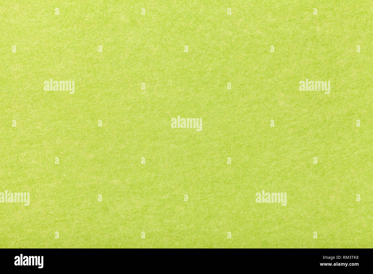Light green matte background of suede fabric, closeup. Velvet texture