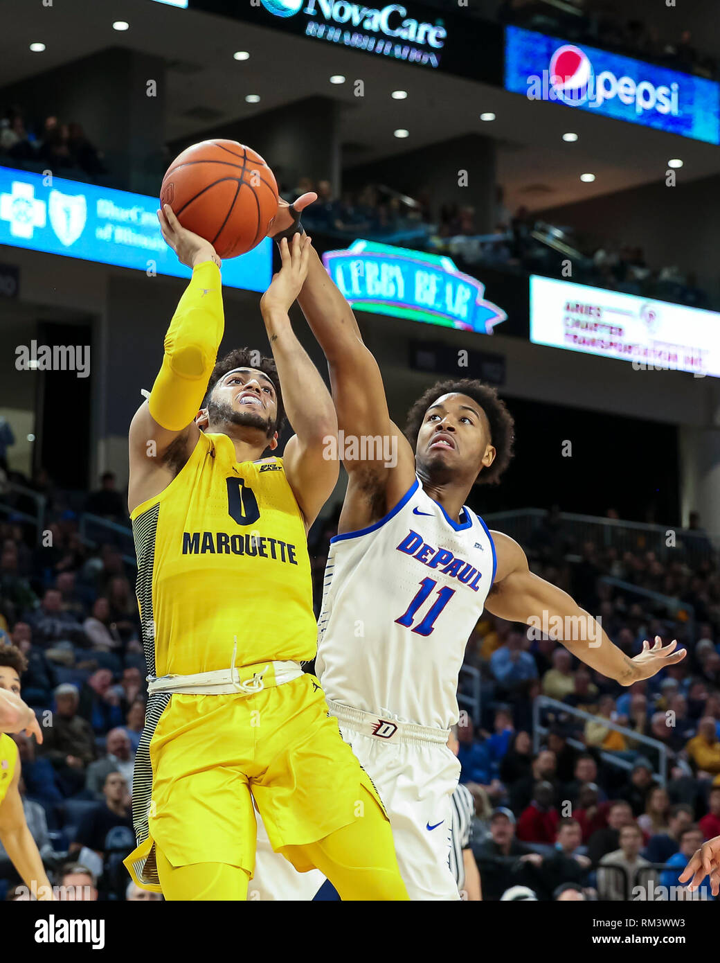 Chicago, USA. 12th Feb 2019. Marquette Golden Eagles guard Markus Howard (0) is fouled by DePaul Blue Demons guard Eli Cain (11) on a drive to the basket during NCAA basketball game between the Marquette Golden Eagles and the DePaul University Blue Demons at Wintrust Arena in Chicago IL. Gary E. Duncan Sr/CSM Credit: Cal Sport Media/Alamy Live News Stock Photo