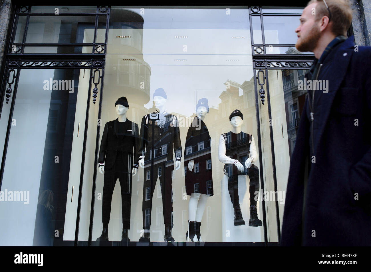 February 9, 2019 - London, United Kingdom - A man seen walking past mannequins in the window of a clothing store on Conduit Street in central London. .February 15 sees the release of the first monthly retail sales figures of the year (for January) from the UK's Office for National Statistics. December figures revealed a 0.9 percent fall in sales from the month before, which saw a 1.4 percent rise widely attributed to the impact of 'Black Friday' deals encouraging earlier Christmas shopping. More generally, with a potential no-deal departure from the EU growing nearer and continuing to undermin Stock Photo