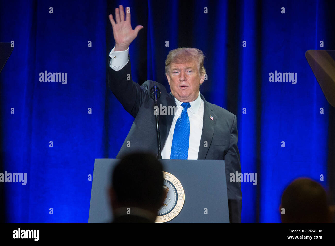 US President Donald J. Trump waves after delivering remarks at the Major County Sheriffs and Major Cities Chiefs Association Joint Conference, in Washington, DC, USA, 13 February 2019. Trump took the opportunity to deliver remarks on his border-security and immigration policy. Republican leaders are asking Trump to sign legislation that allocates about 1.375 billion USD (1.218 billion euros) for over fifty miles of physical barriers along the border. Signing the agreement would prevent another partial shutdown of the federal government that would begin 16 February. Credit: Michael Reynolds/P Stock Photo