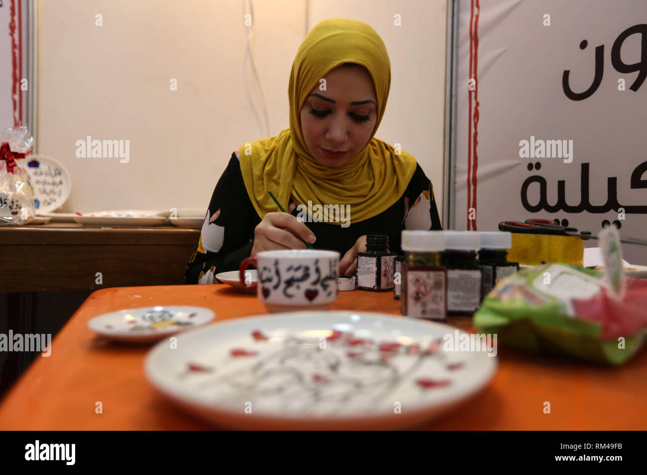 Gaza. 13th Feb, 2019. A Palestinian woman exhibits her products during a shopping festival in Gaza City, on Feb. 13, 2019. For the first time in the Palestinian Gaza Strip, a shopping festival has provided an opportunity for owners of emerging companies and businesses to display and market their products. Credit: Stringer/Xinhua/Alamy Live News Stock Photo