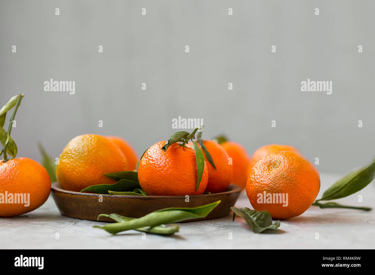 Ripe mandarines fruits with leaves, fresh citrus fruits on concrete background with copy space still life Stock Photo