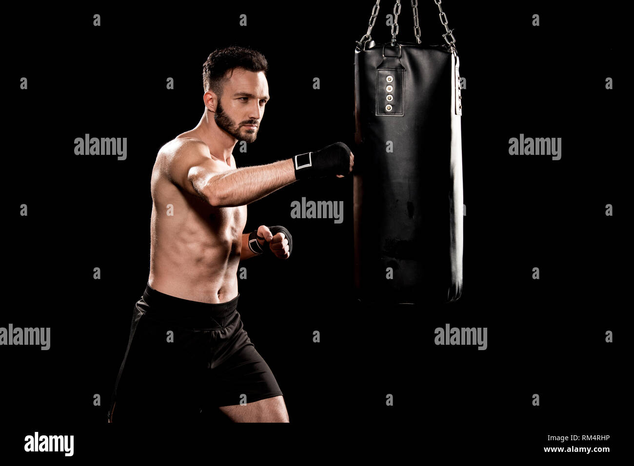muscular boxer hitting punching bag isolated on black Stock Photo Alamy