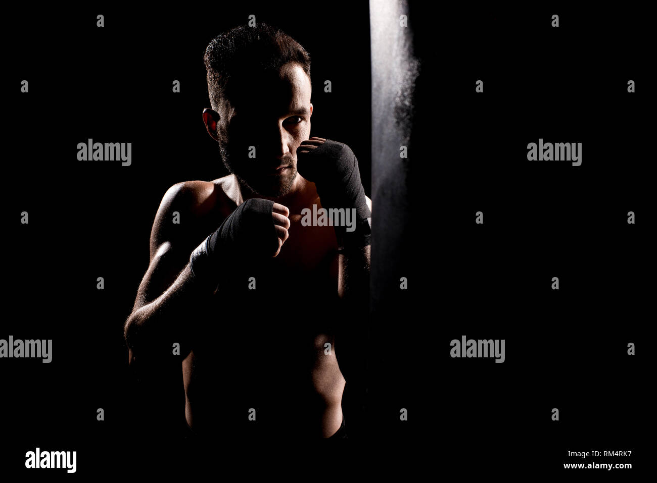shortless athlete hitting punching bag isolated on black Stock Photo Alamy