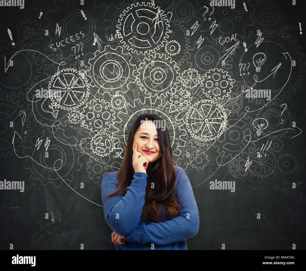 Hard thinking smart woman standing in front of blackboard as gear cogwheels, arrows and mess as thoughts drawn around head. Concept for mental, psycho Stock Photo