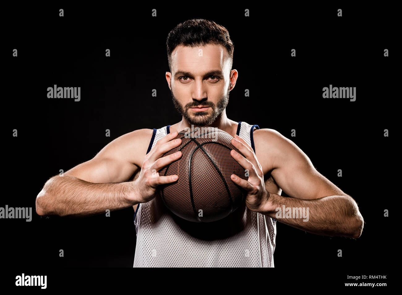 serious basketball player holding ball isolated on black Stock Photo Alamy
