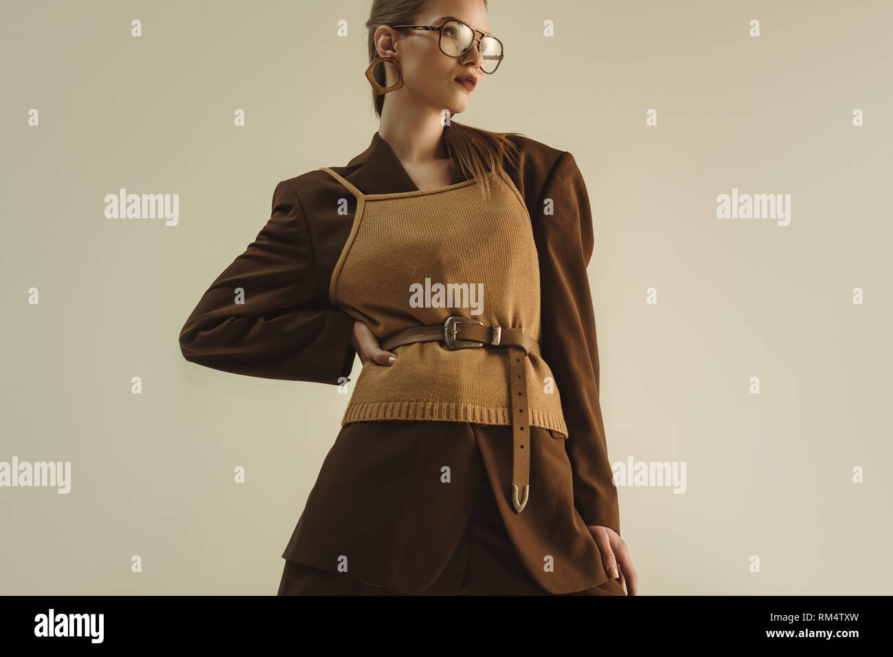 stylish model posing in trendy retro clothing for fashion shoot isolated on beige Stock Photo