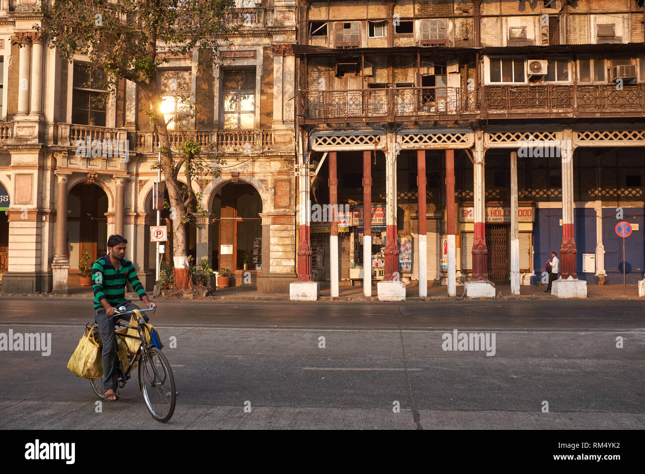 A cyclist passes 19th century Esplanade Mansion, Mumbai, originally Watson's Hotel, the first luxury hotel in Kala Ghoda, Fort, Mumbai / Bombay, India Stock Photo