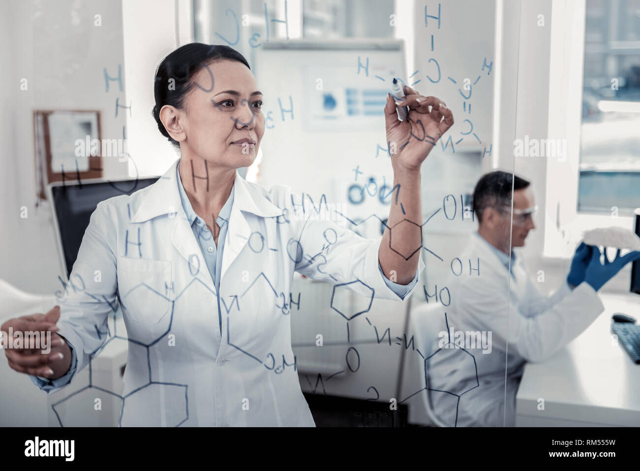 Scientist is making notes on the glass board Stock Photo