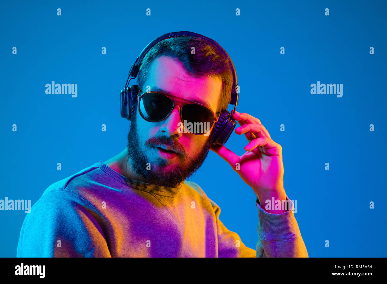 Enjoying his favorite music. Serious young stylish man in sunglasses