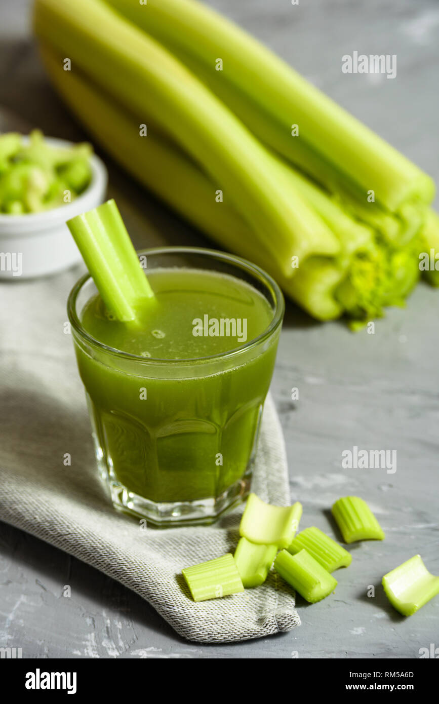 Celery Healthy Green Juice in glass on grey background Stock Photo