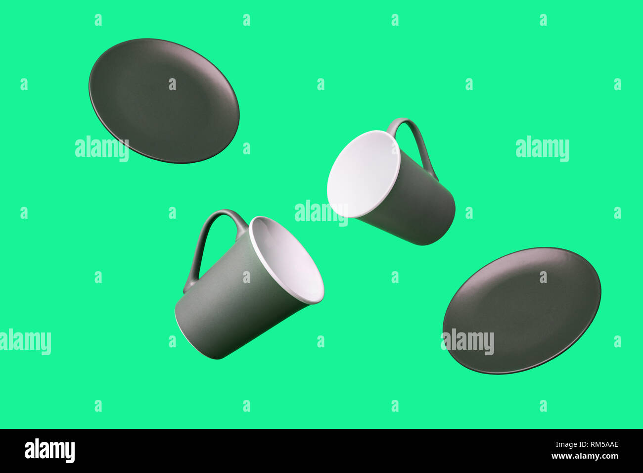 Flying Concept of Gray Brown Porcelain Coffee Tea Cups and Plates on Green Background Decorative Minimal Style Background Stock Photo