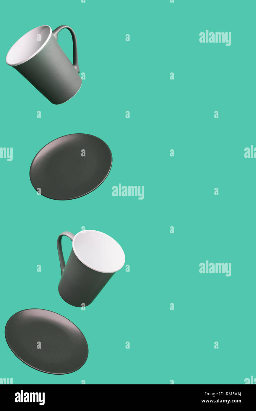 Flying Concept of Gray Brown Porcelain Coffee Tea Cups and Plates on Green Background Decorative Minimal Style Background Stock Photo