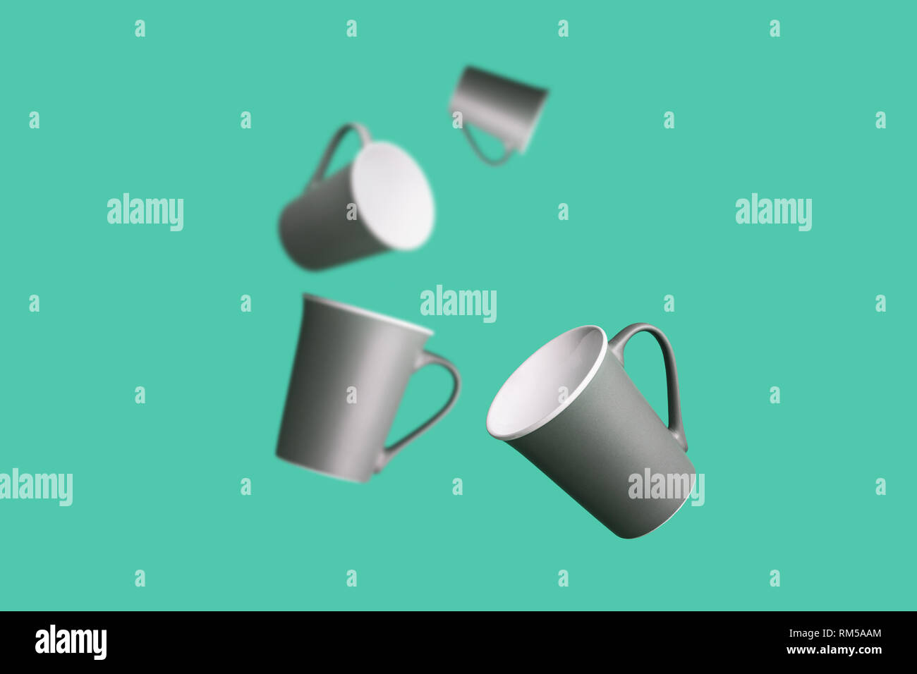 Flying Concept Group of Dark Brown Gray Porcelain Coffee Tea Cups on Green Background Minimal Style Stock Photo