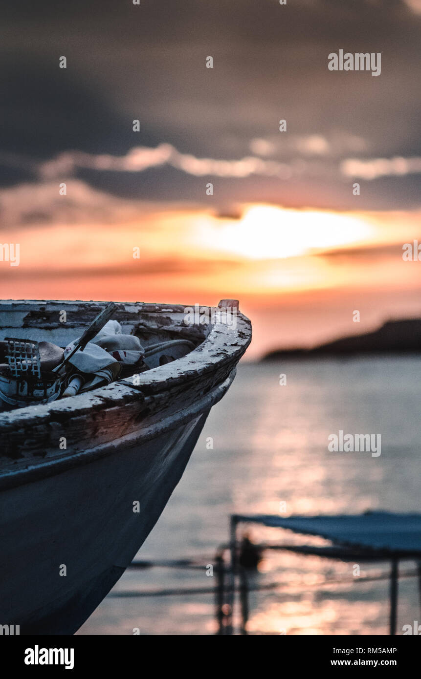 old fishing boat on sunset with paint coming off and left as derelict Stock Photo
