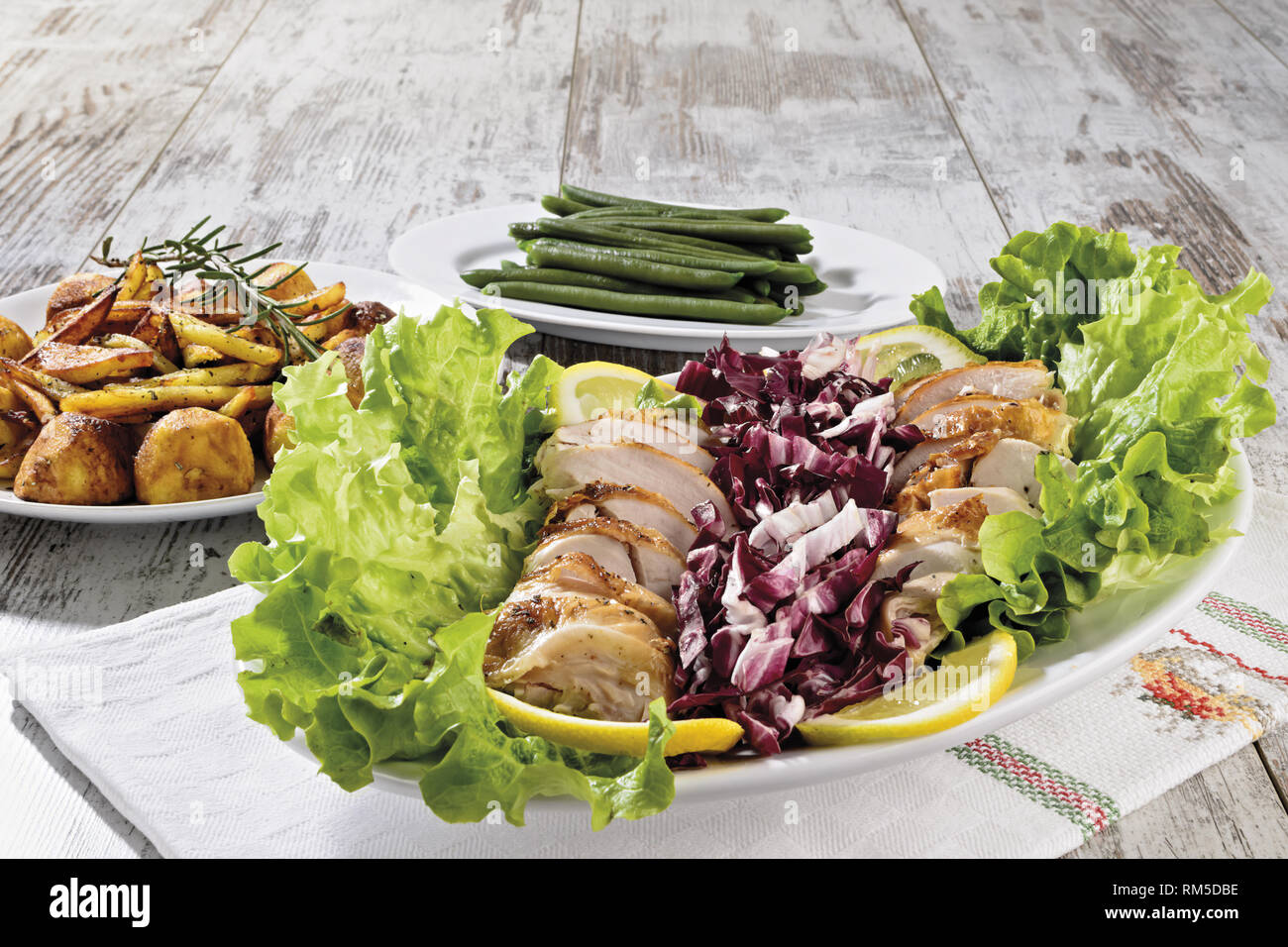 petto di pollo a fette con insalata patate fritte e fagiolini fronte Stock Photo