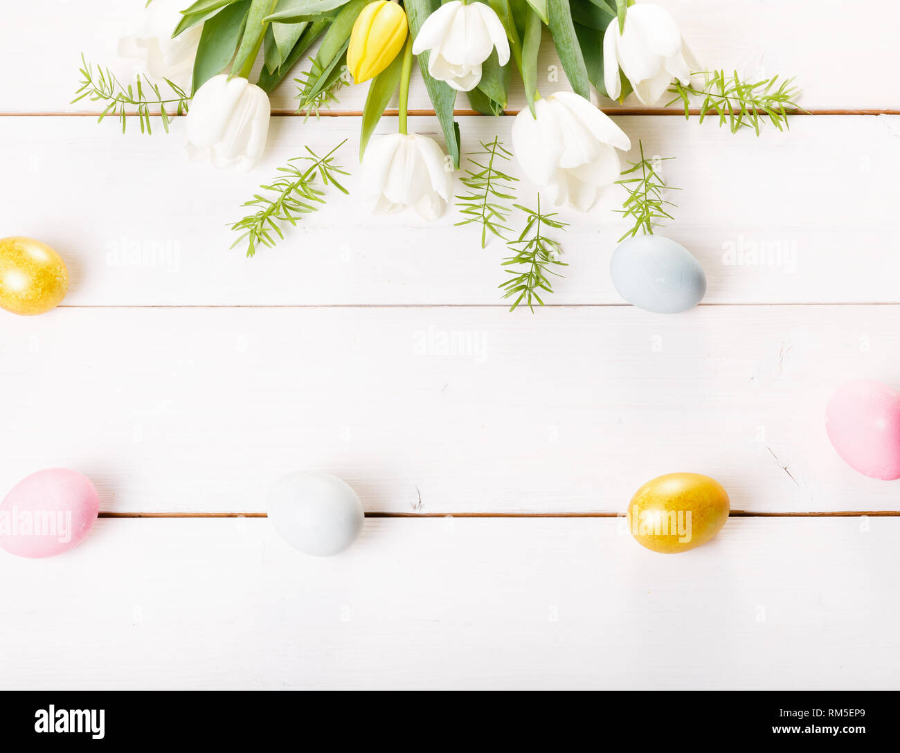 Easter background with Easter eggs and spring flowers. Top view with ...