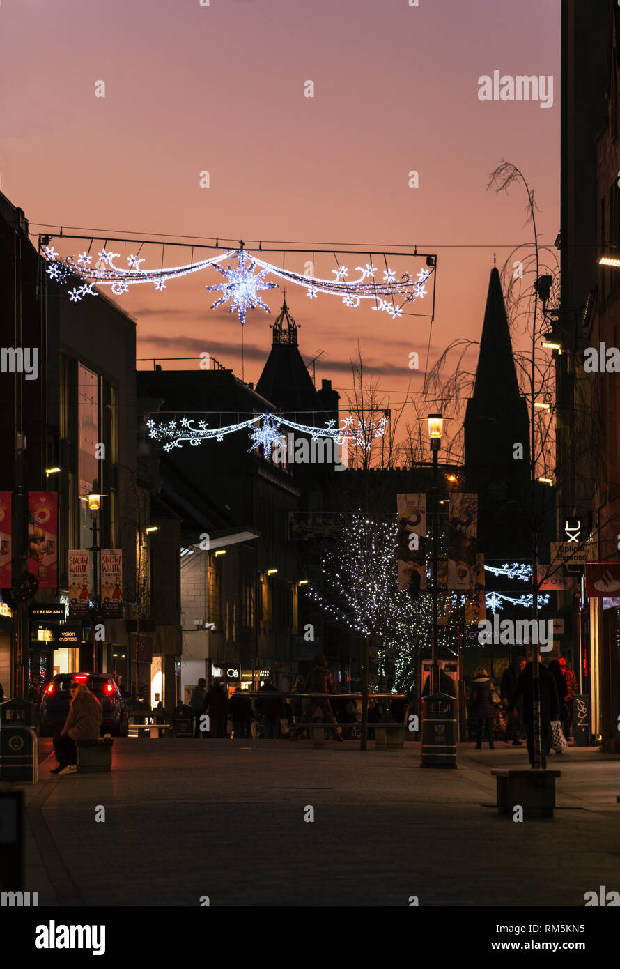 High street shoppers under Christmas lights at dusk in Perth, Scotland, UK Stock Photo