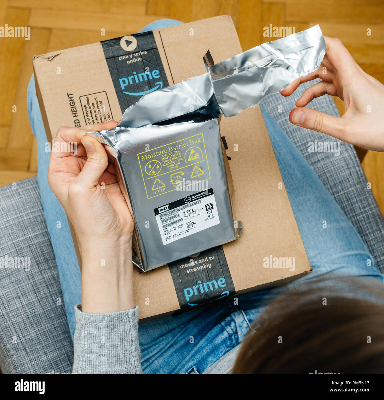 PARIS, FRANCE - NOV 4, 2017: Curious woman unboxing on the living room  armchair the Amazon Prime cardboard box with Western Digital 6 terabyte HDD  hard disk drive from antistatic pouch Stock Photo - Alamy