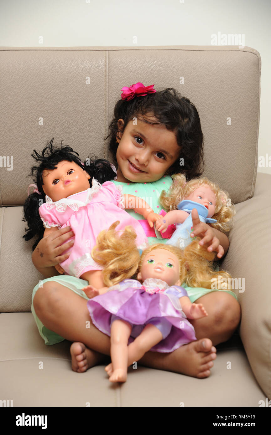 Little girl playing with dolls child with doll Stock Photo