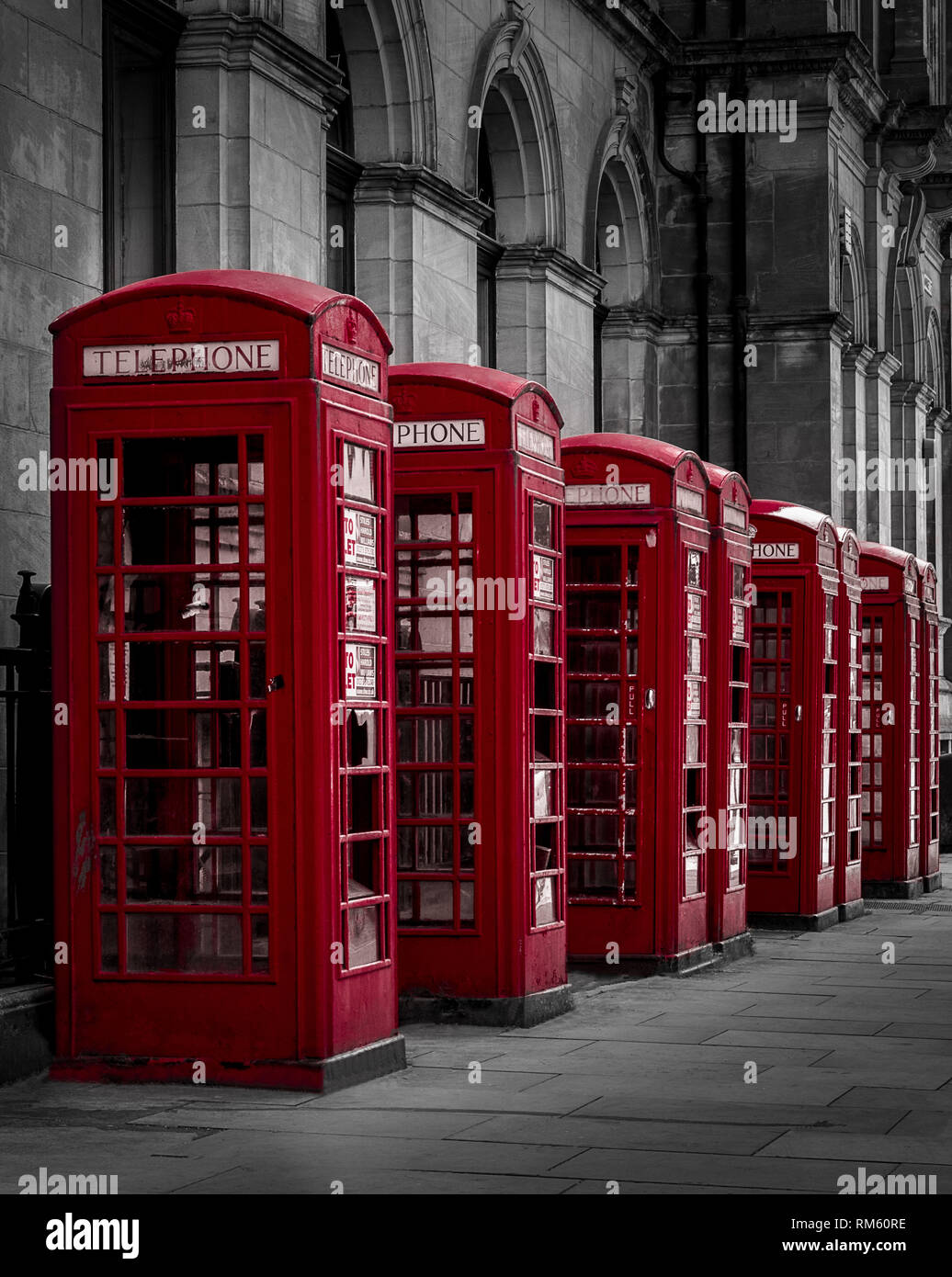 Red Phones boxes in a selective color black and white shot. Preston, Lancashire Stock Photo