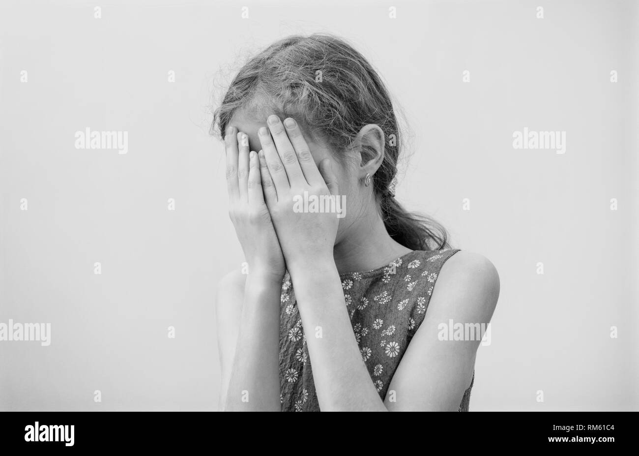 Sad little girl crying at home. Stock Photo