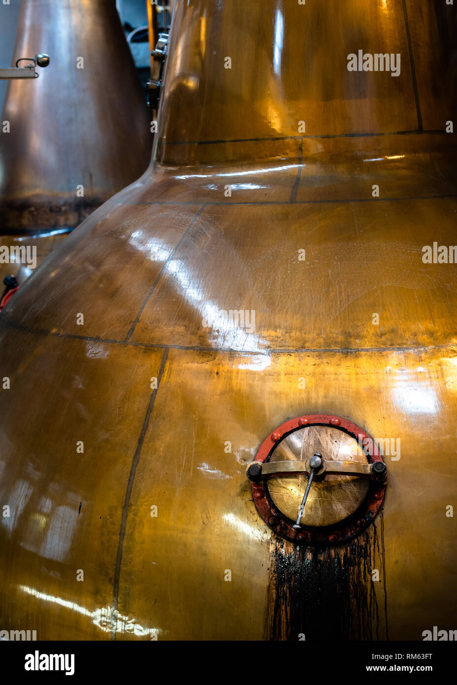 Old copper whisky pot still showing the opening hatch at the Balblair whisky distillery, Edderton, Ross-shire, Scotland Stock Photo