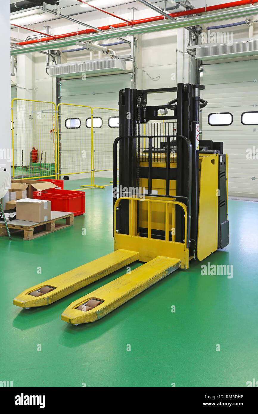 Electric forklift truck in distribution warehouse Stock Photo - Alamy
