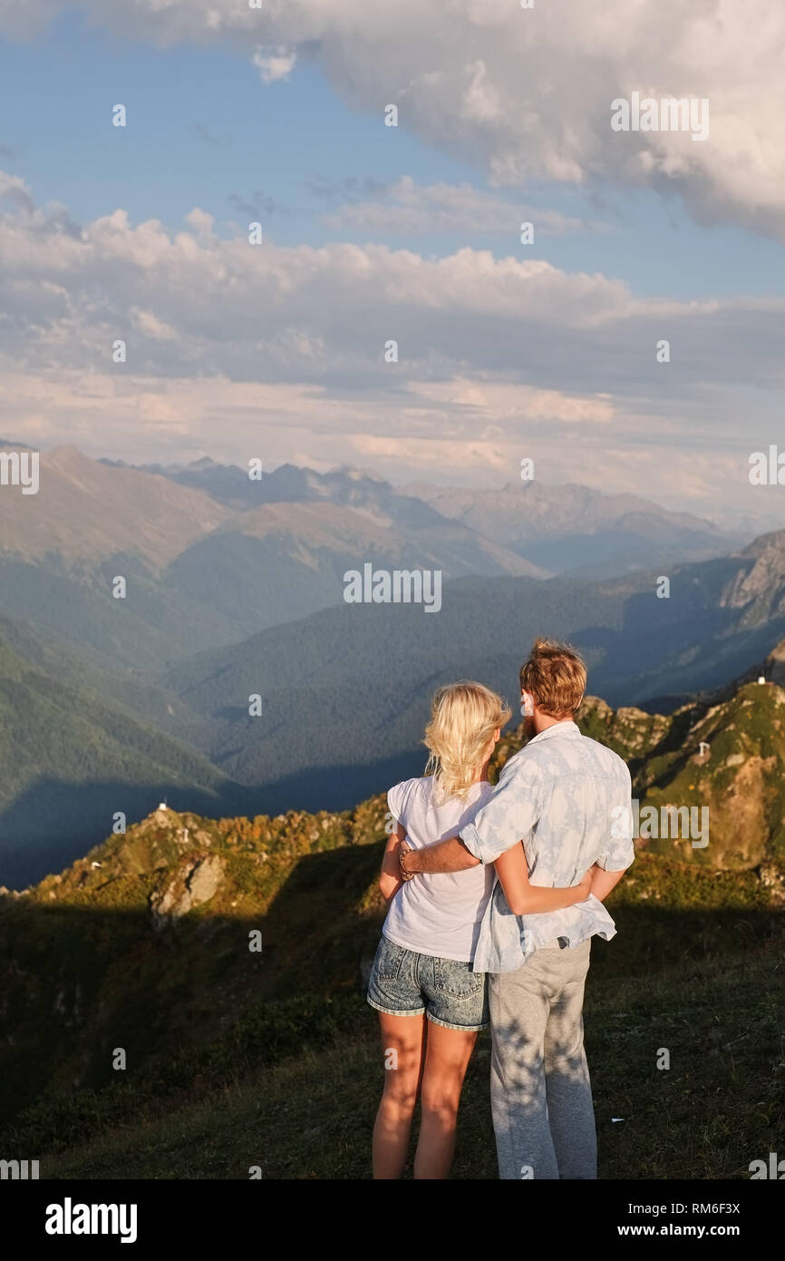 View of the couple watching the sunset on the top of the mountain Stock ...