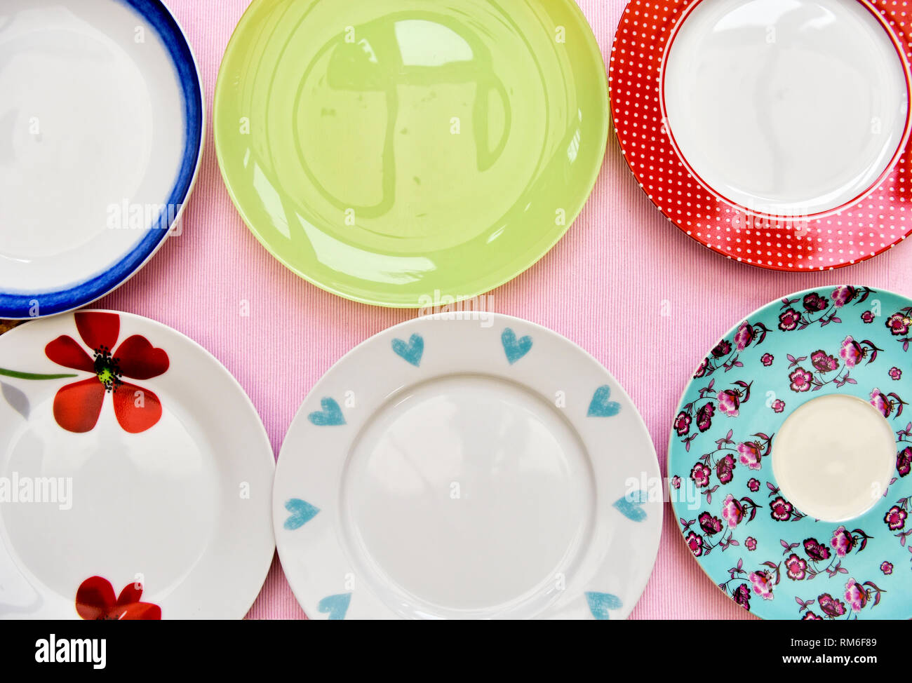 A selection of six pretty tea plates against a pink background taken from an overhead view Stock Photo