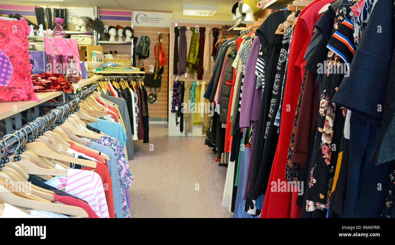 Clothes rails inside a charity shop, Buckinghamshire, UK Stock Photo