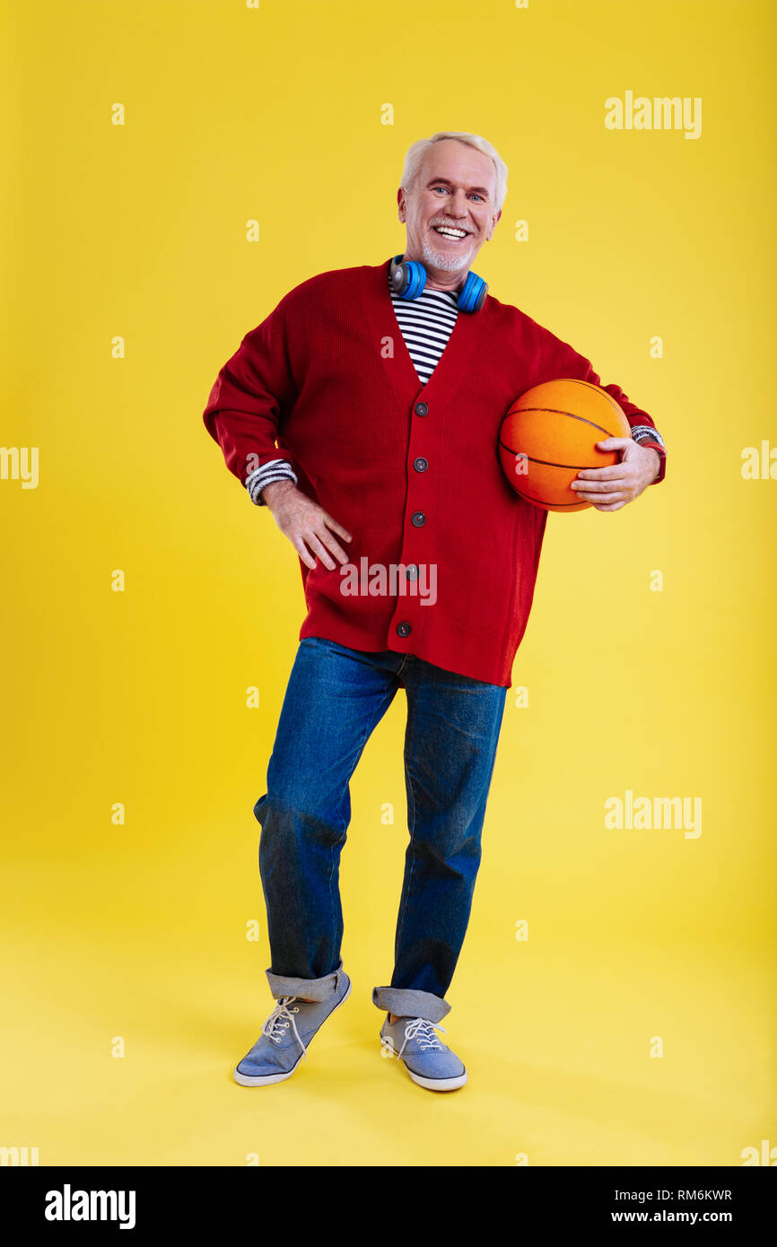 Pensioner wearing jeans leading healthy lifestyle and loving basketball