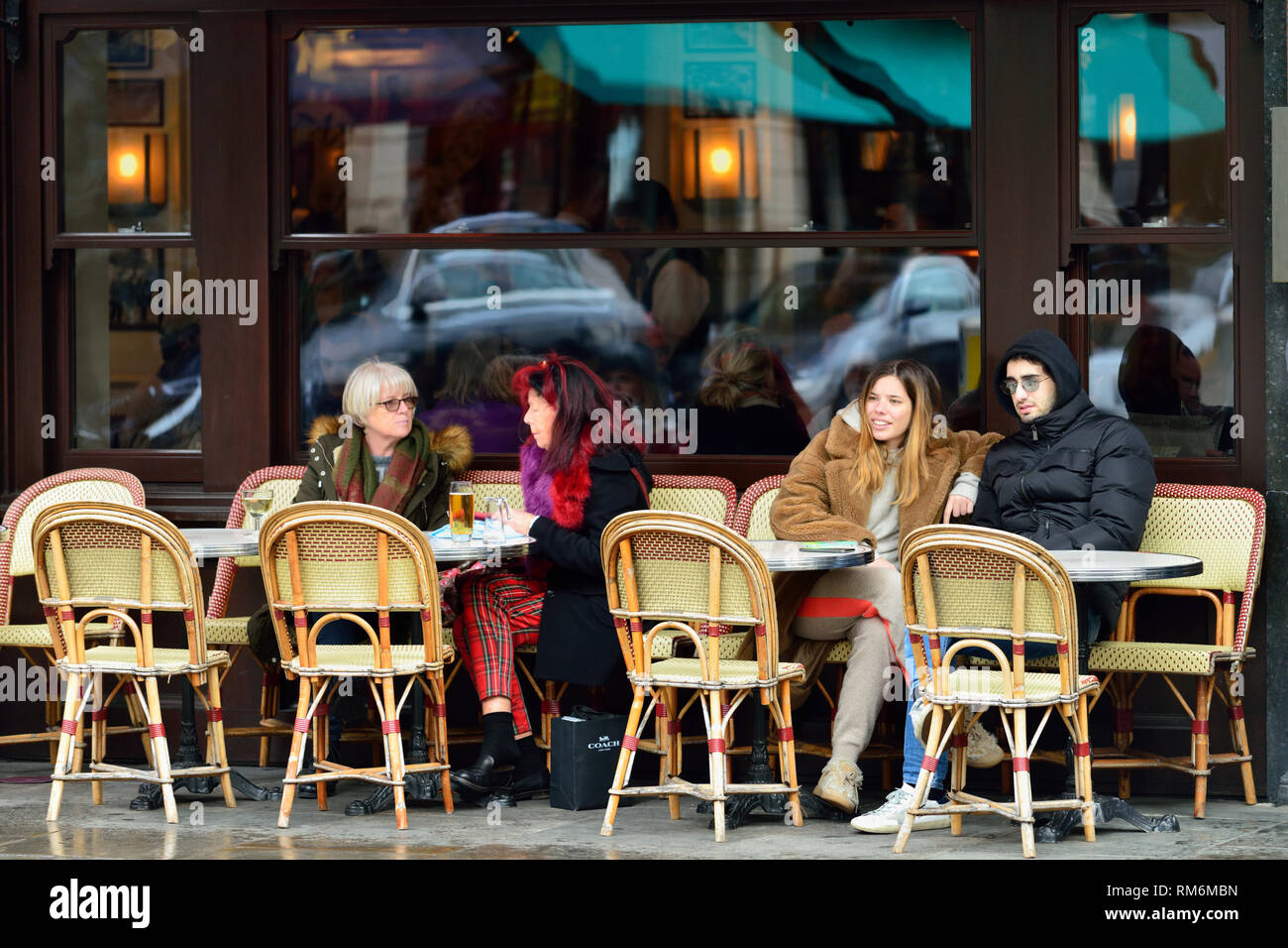 Customers taking refreshments sitting outside a Sloane Square restaurant, Sloane Square, Kensington and Chelsea, West London, United Kingdom Stock Photo