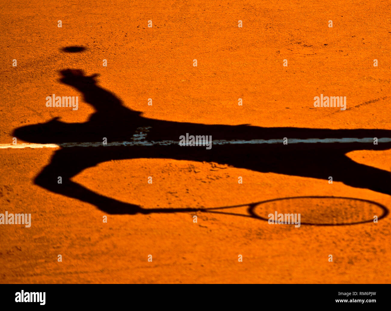 Shadow of a tennis player serving Stock Photo