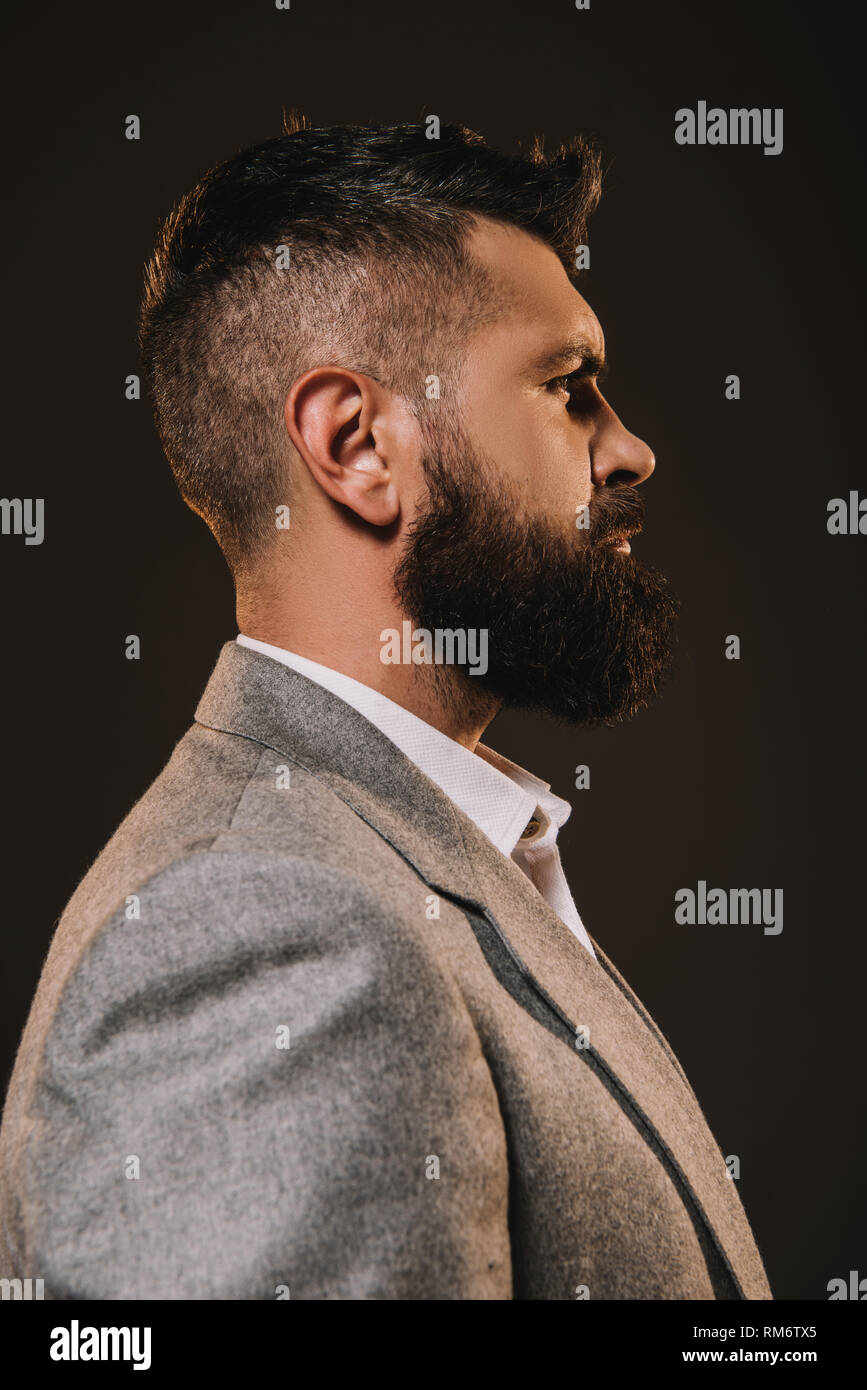 profile portrait of handsome beard businessman isolated on brown Stock Photo