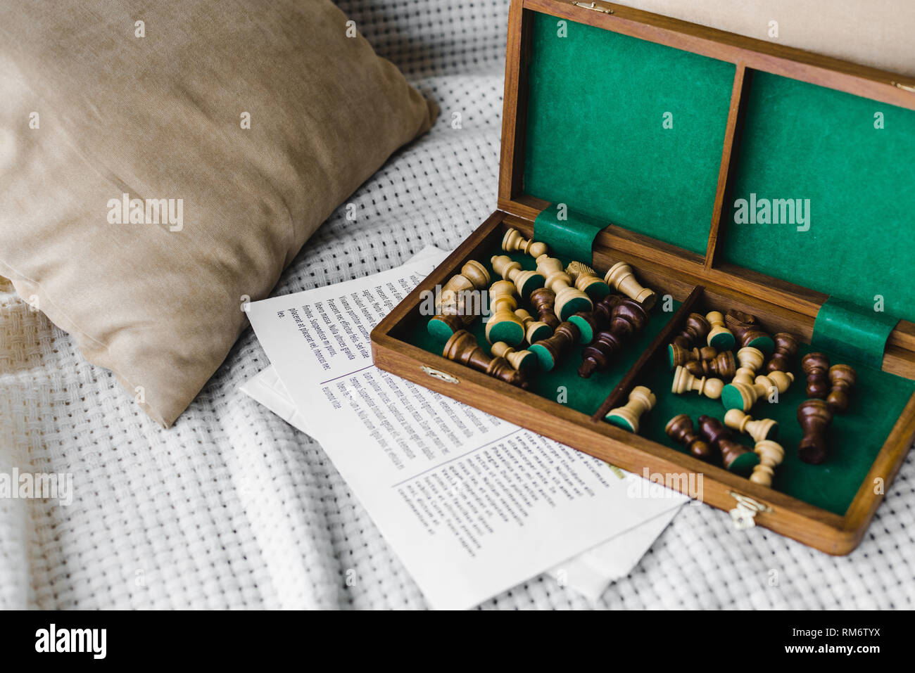 wooden chess board near newspaper on sofa at home Stock Photo